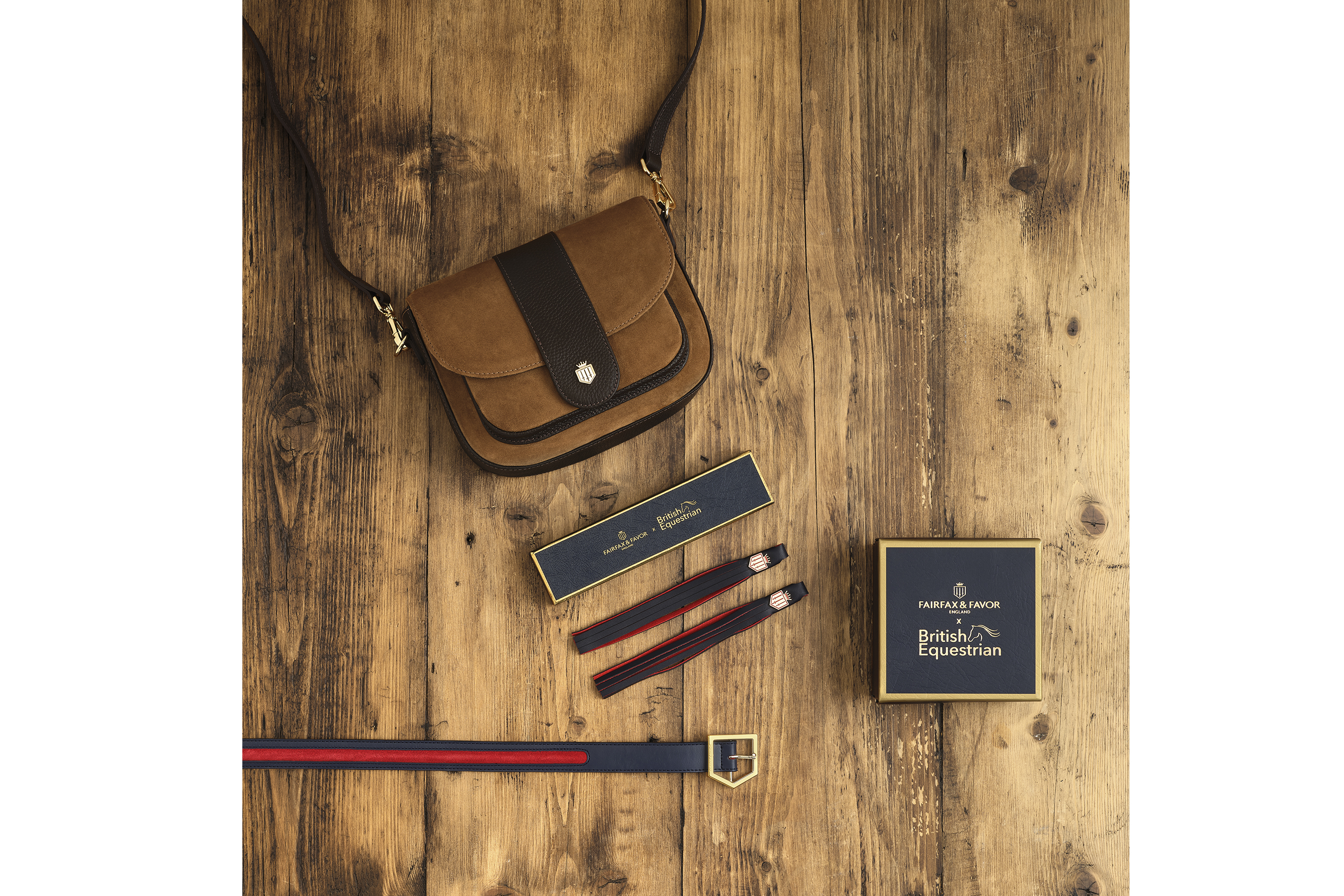 Brown hand bag with belt and tassels sitting on a wooden table as a flat lay photo shoot